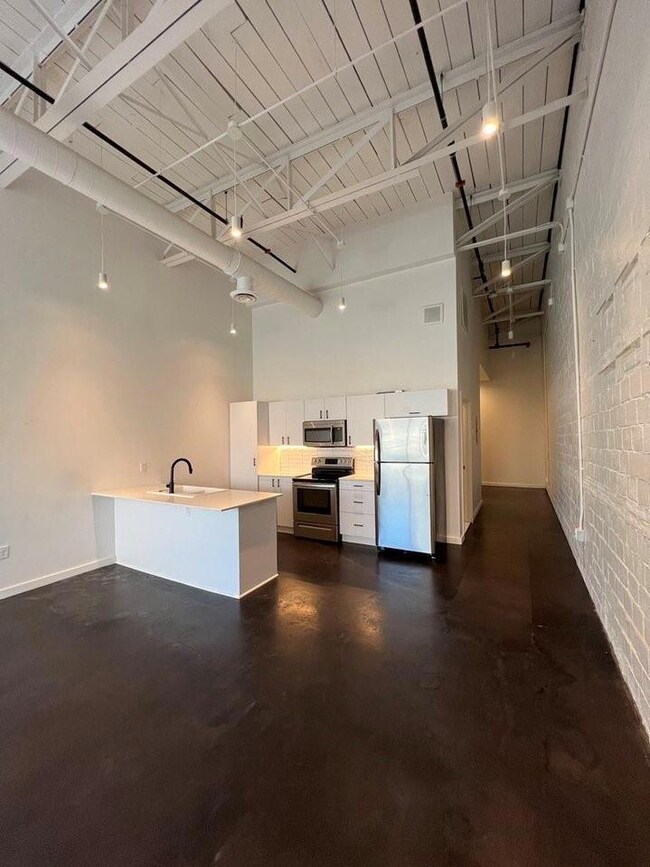 Kitchen featuring a towering ceiling, white cabine