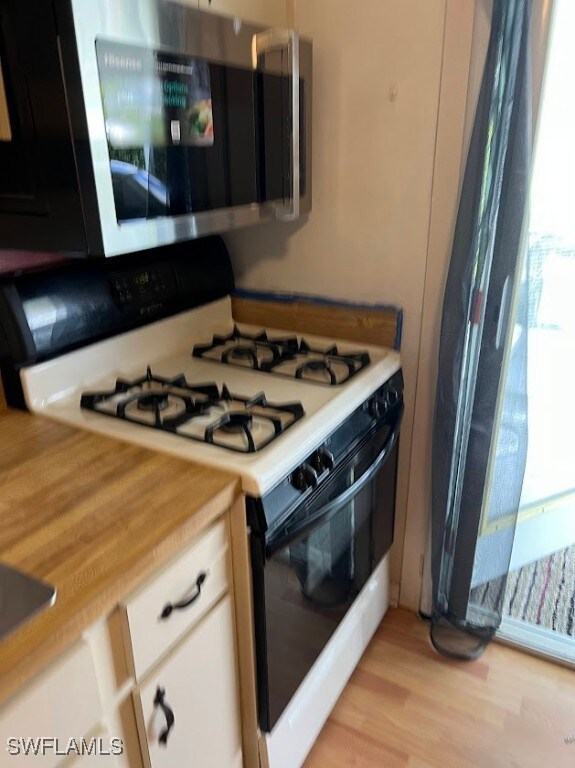 Kitchen featuring gas stove, light countertops, st