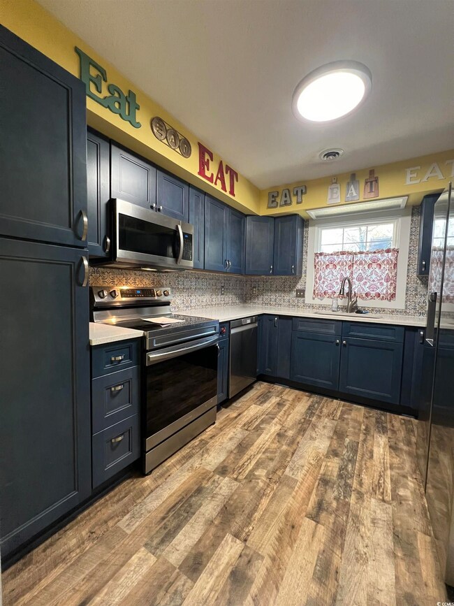 Kitchen featuring light wood-type flooring, applia