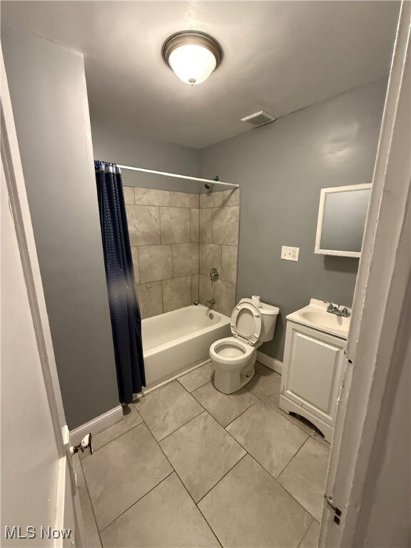 Bathroom with shower / bath combo, vanity, and light tile patterned floors