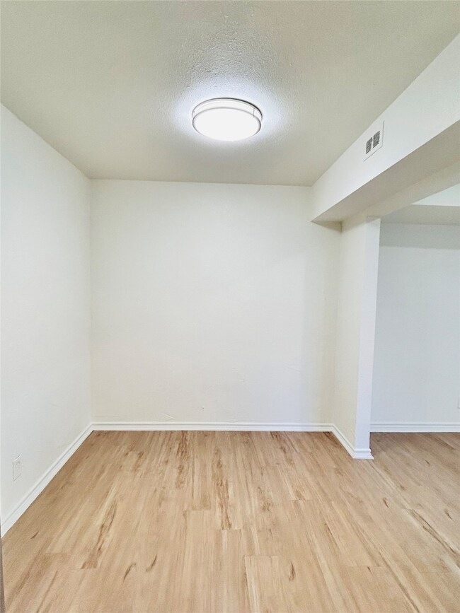 Empty room featuring light wood-style flooring and a textured ceiling