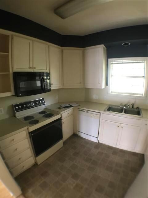 Kitchen featuring white cabinetry, a sink, white 