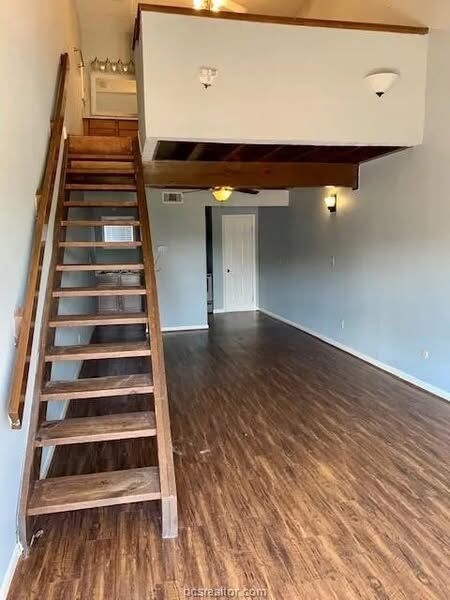 Stairs with wood-type flooring and ceiling fan