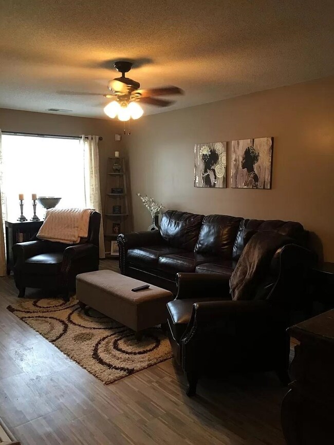 Living room featuring ceiling fan, wood-type floor