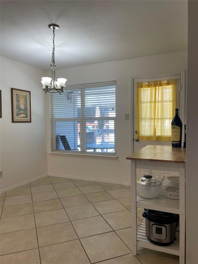 Dining room featuring a chandelier, light tile pa