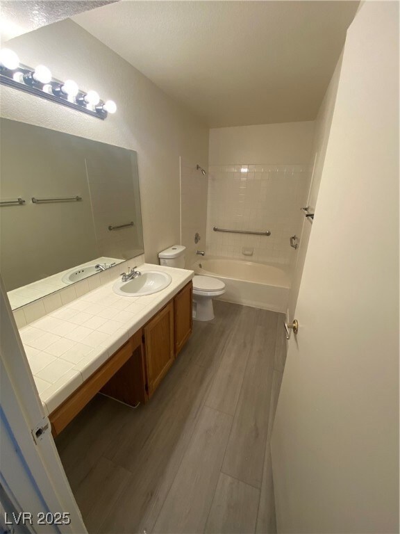 Bathroom featuring vanity, light wood finished floors, and shower / tub combination