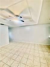 Basement with light tile patterned flooring and baseboards