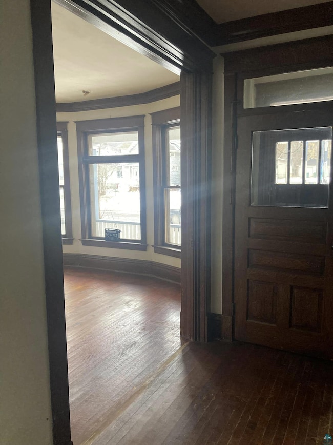 Entryway featuring wood-type flooring and crown mo