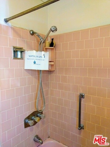 Bathroom has tub with shower