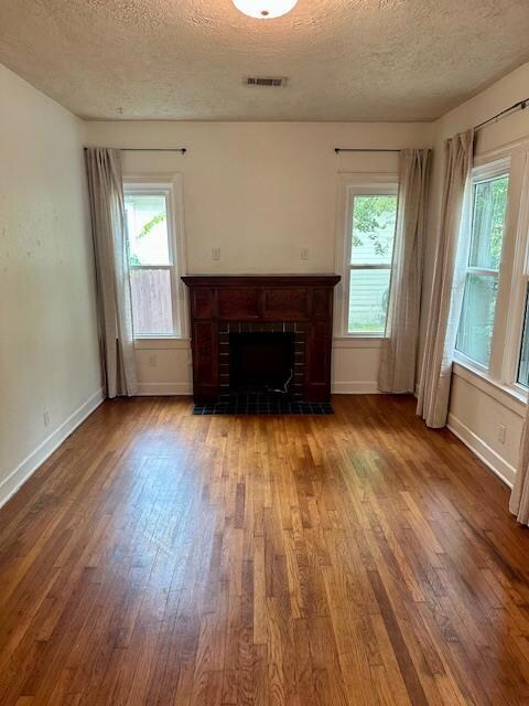 Unfurnished living room featuring baseboards, a f
