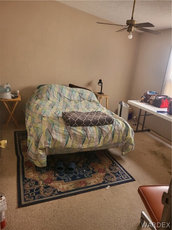 Bedroom with a textured ceiling, carpet flooring,