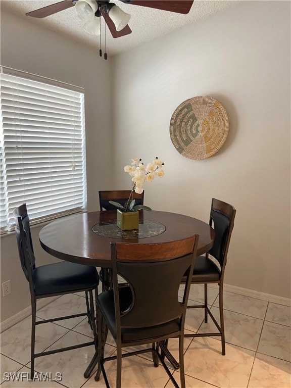 Dining room with baseboards, a textured ceiling, a