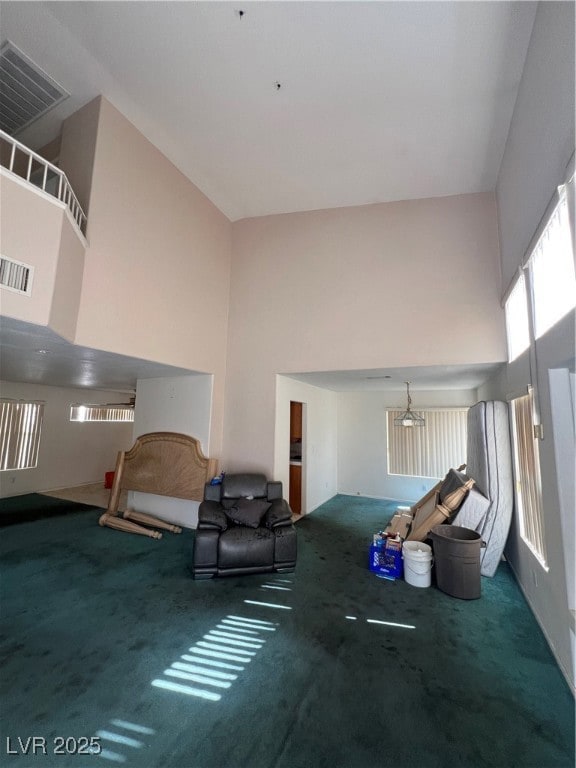 Carpeted living room featuring a towering ceiling