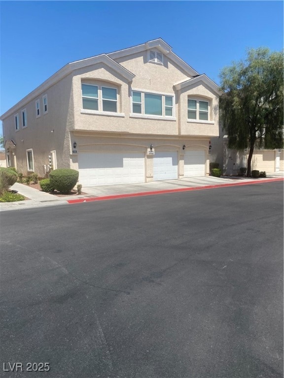 View of front of home featuring stucco siding and a garage