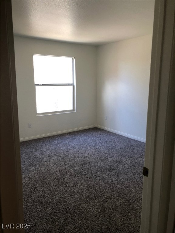 Empty room featuring dark carpet