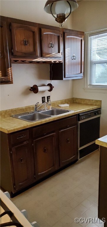 Kitchen featuring dark brown cabinets, sink, and d