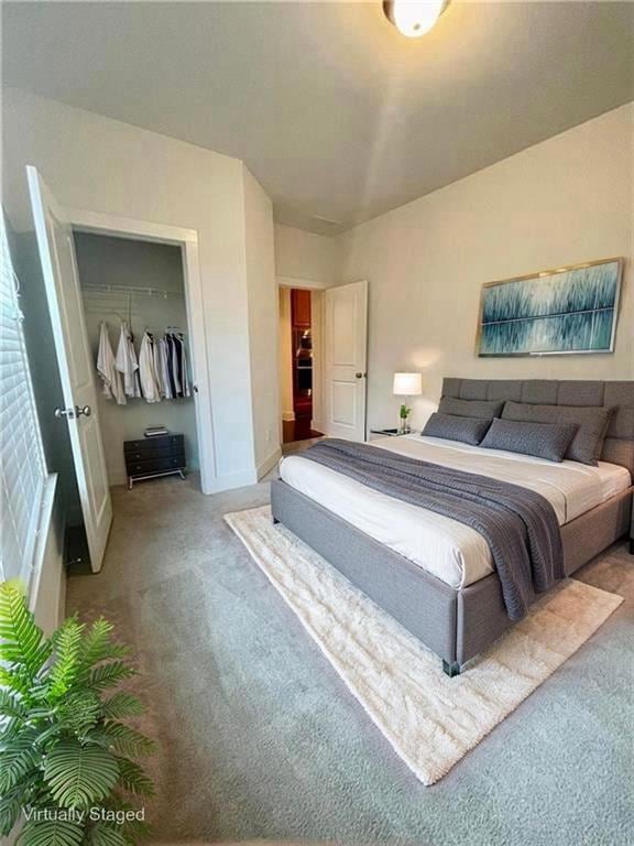 Bedroom featuring carpet, a closet, baseboards, and a walk in closet