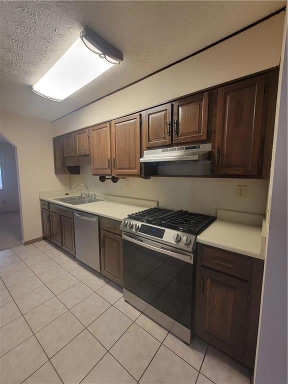 Kitchen featuring a textured ceiling, a sink, dish