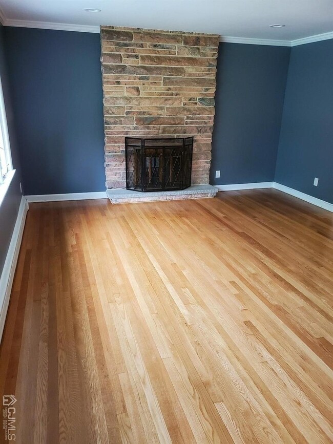 Living room with wood burning fireplace and hardwo