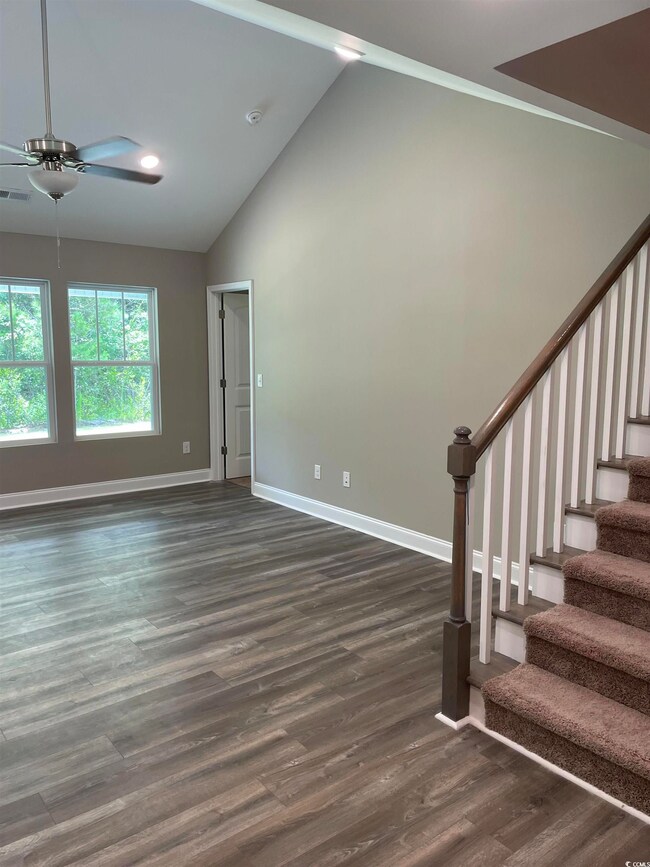 Unfurnished living room featuring a towering ceili