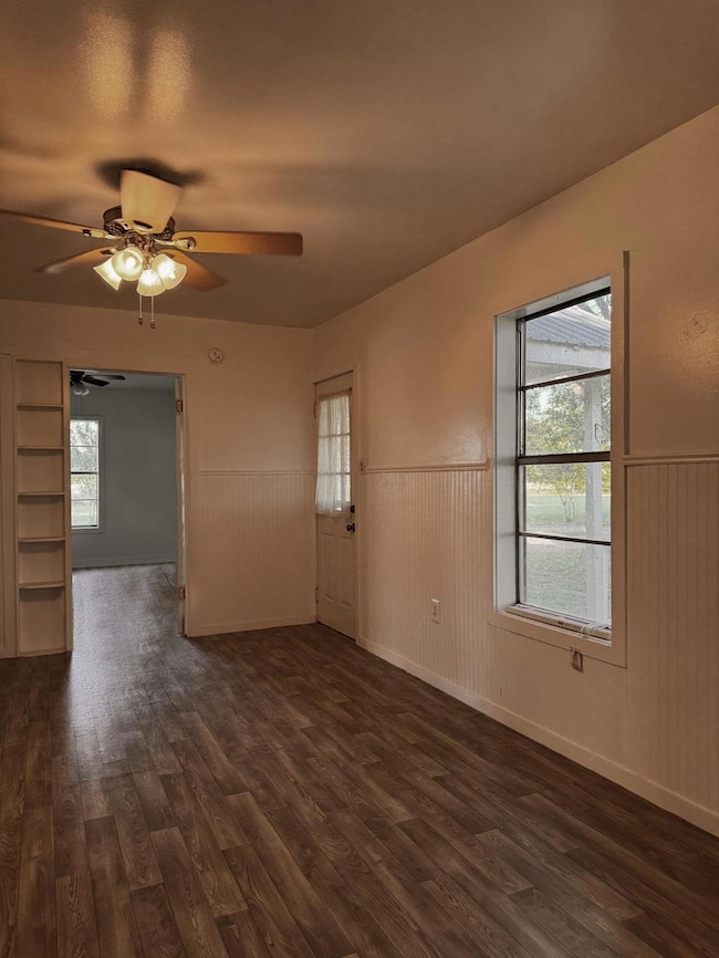 Spare room with a wainscoted wall, dark wood-styl