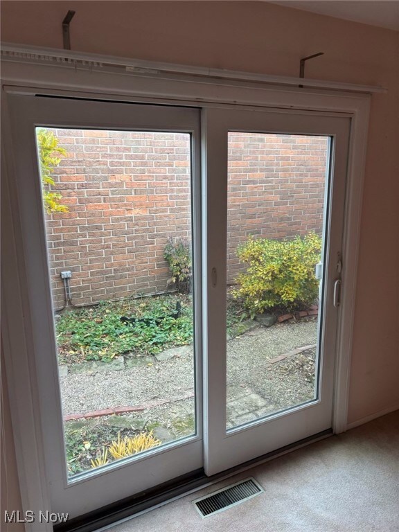 Doorway featuring carpet floors
