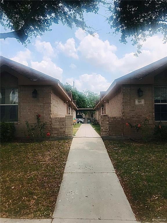 View of side of home with brick siding and a lawn