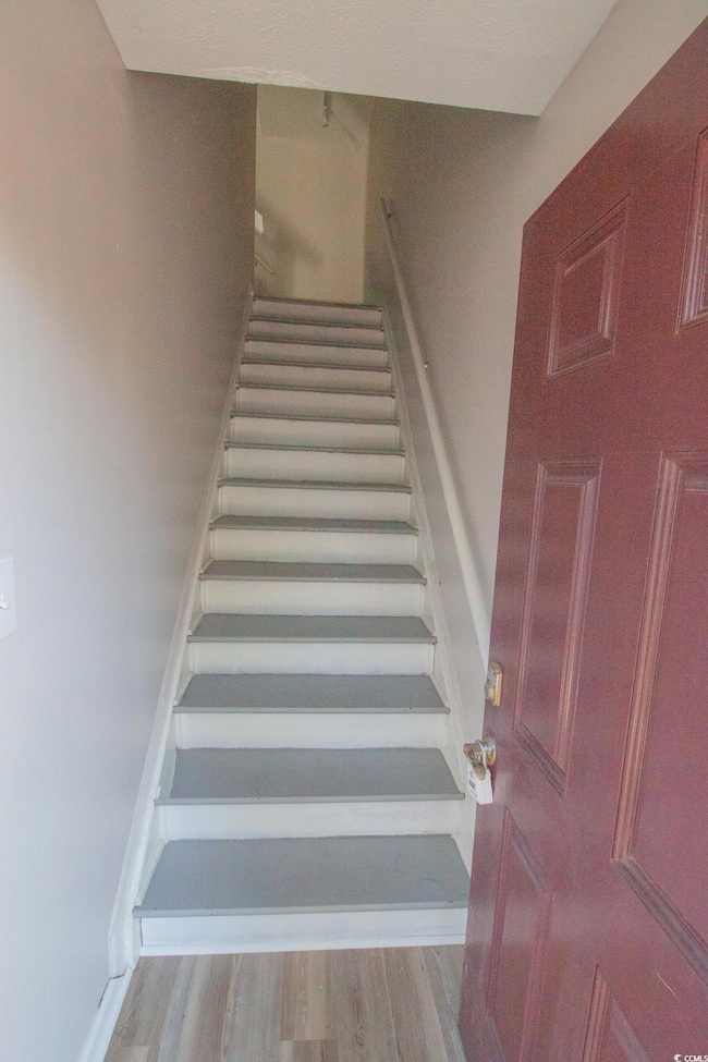 Stairway featuring wood finished floors