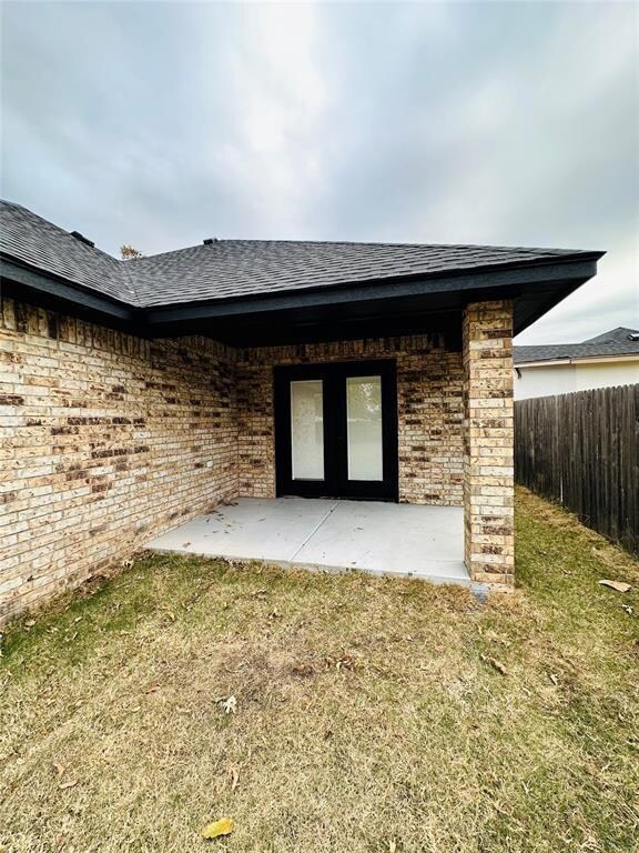 Back of property with a lawn and a patio