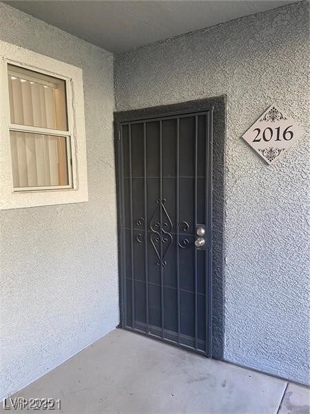 Doorway to property with stucco siding