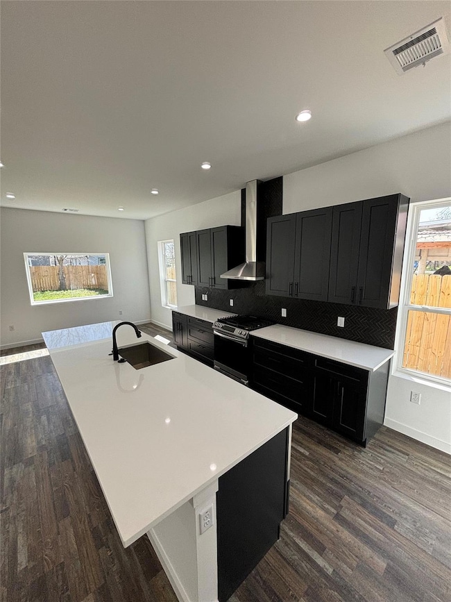 Kitchen featuring wall chimney range hood, stainl