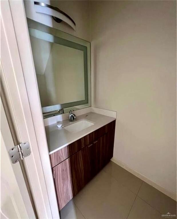 Bathroom featuring vanity, baseboards, and tile patterned flooring