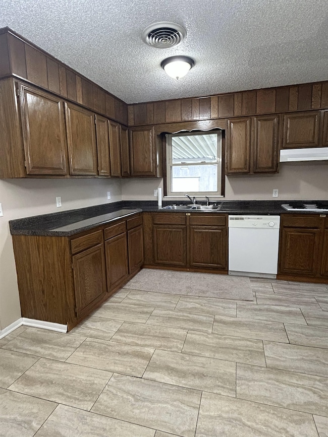 Kitchen featuring dishwasher, a sink, wood tiled f