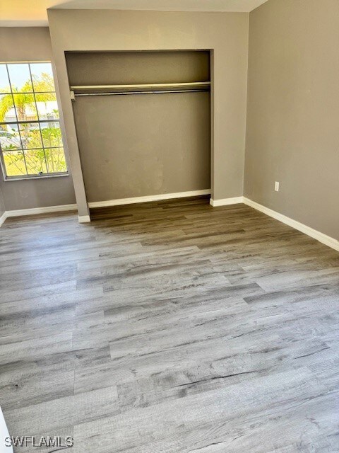 Unfurnished bedroom with a closet, wood finished f