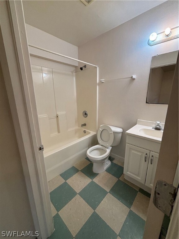 Full bathroom with tile flooring, shower / bath combination, toilet, and vanity