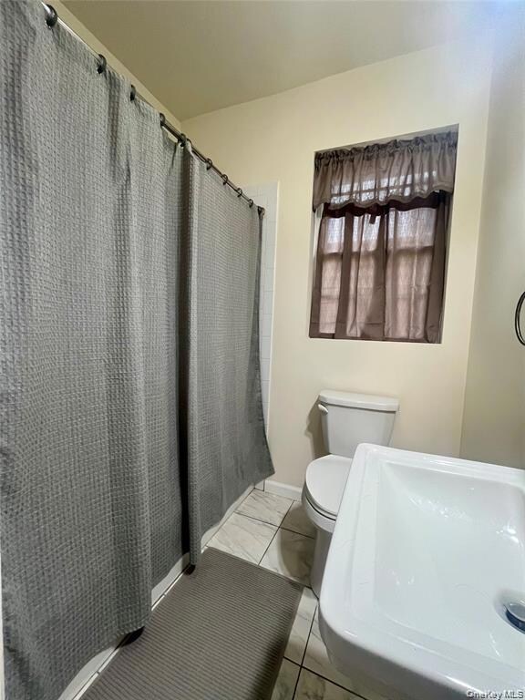 Bathroom with curtained shower and a sink