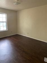 Empty room with dark wood-style floors and baseboards