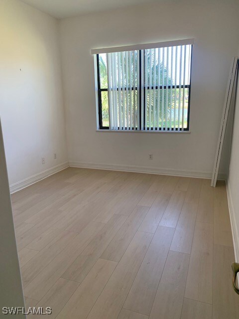 Unfurnished room with baseboards and light wood-st
