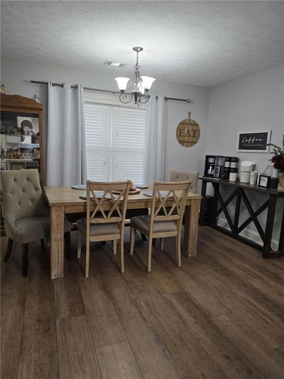 Dining room with dark wood-type flooring, a chande