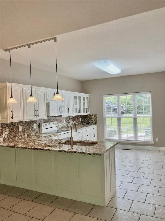 Kitchen has exotic granite counters and backsplashes, and freshly painted cabinets