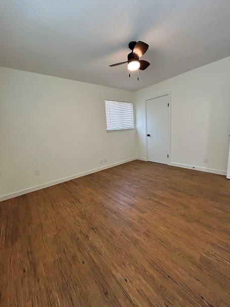 Empty room with dark wood finished floors and a c