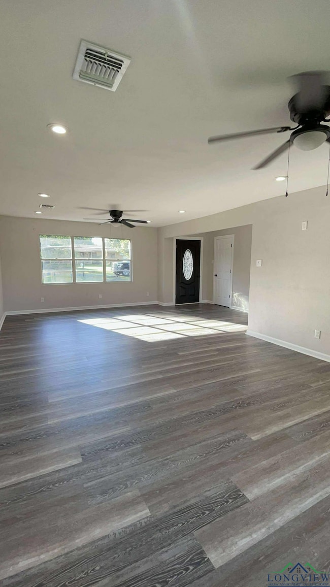 Unfurnished living room featuring a ceiling fan, baseboards, wood finished floors, and recessed lighting