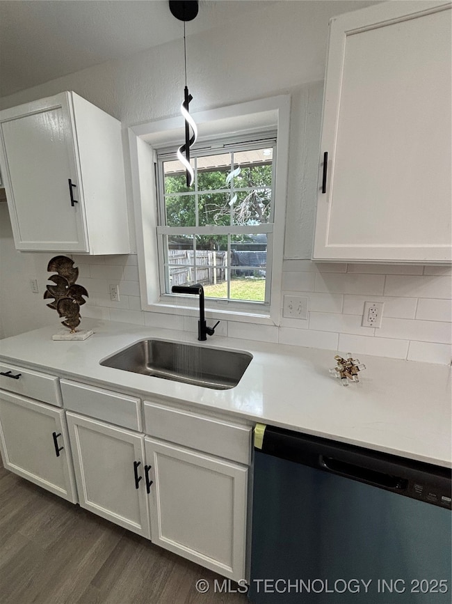 Kitchen featuring dishwasher, a sink, white cabine