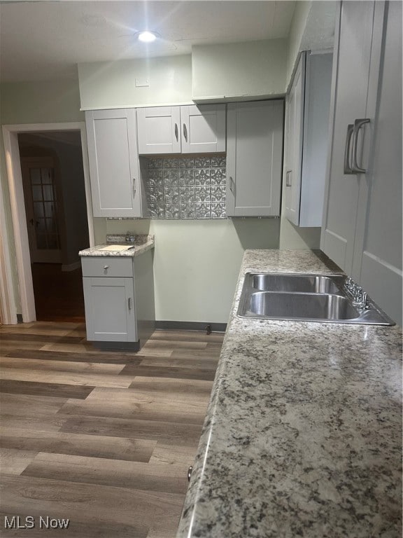 Kitchen with dark wood-style flooring and gray cabinetry