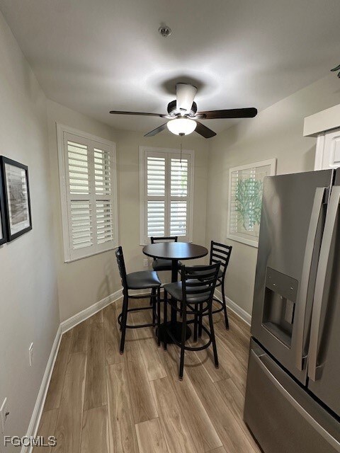Dining area featuring light wood finished floors, healthy amount of natural light, and a ceiling fan