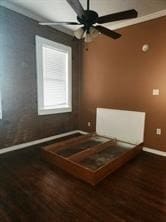 Bedroom with ceiling fan, dark wood-type flooring, and radiator heating unit