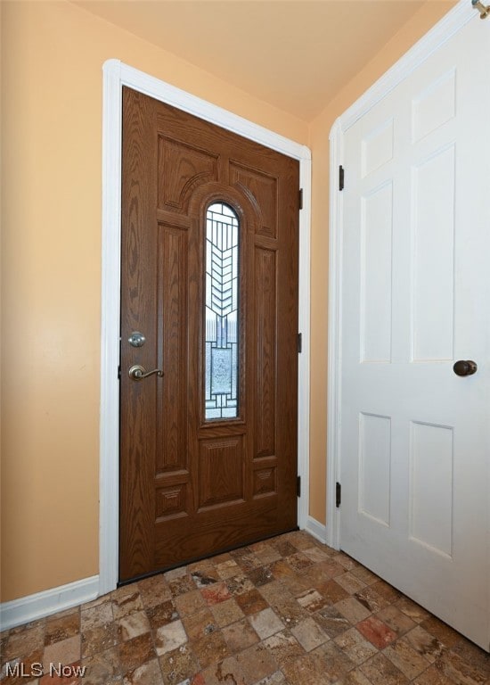 Foyer entrance with tile floors and closet.