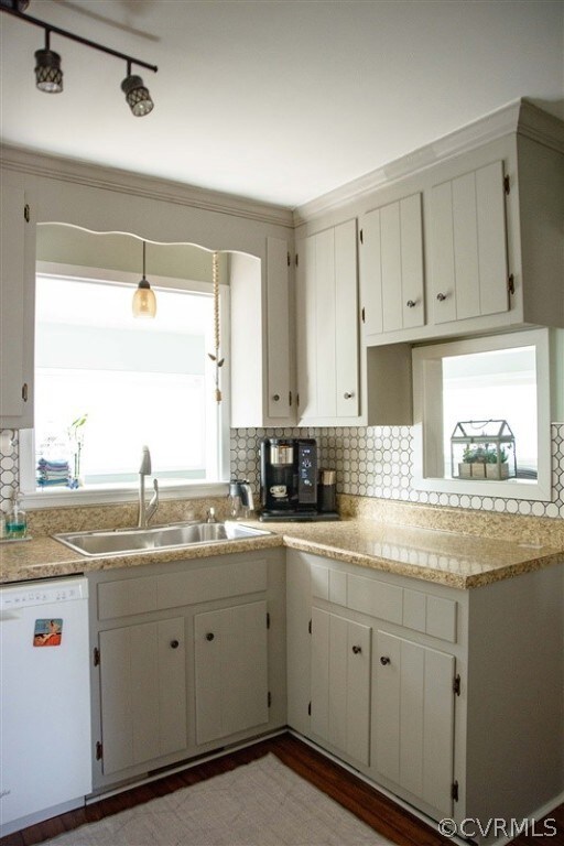Kitchen featuring white cabinets, tasteful backspl