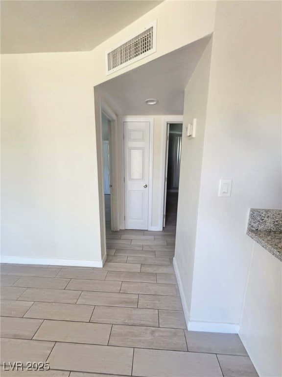 Hallway featuring wood finish floors and baseboard