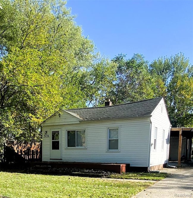 View of front of house featuring a chimney, a front lawn, and a shingled roof